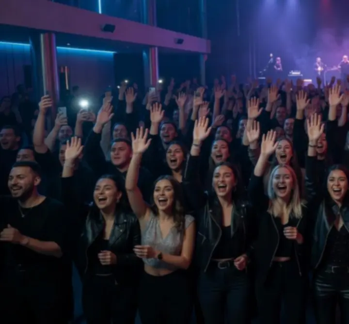 Koncert közönség felemelt kezekkel, éjszakai klub hangulat